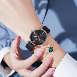 Close-up of minimalist rose gold watch with black leather strap and green gemstone bracelet