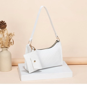Detail of white textured shoulder bag with golden hardware and matching coin purse