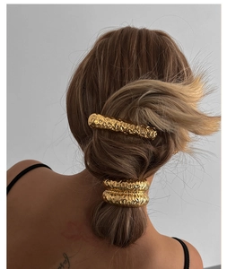 Rear view of model wearing gold hammered metal hair clip and elastic hair tie set