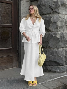 Chic white V-neck lantern sleeve top and maxi skirt set with elegant waist tie detail
