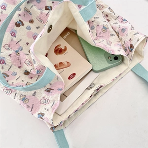 Detail view of the cat canvas tote with magnetic buckle, quilted texture and cute cartoon print