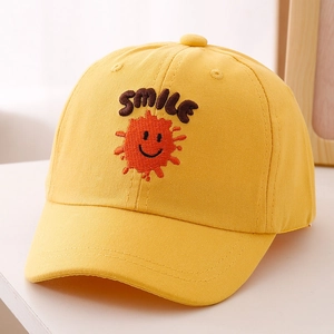 Detail of yellow cotton kids baseball cap featuring brown SMILE embroidery and orange face