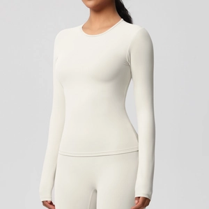 Détail d'un haut de yoga beige à manches longues coupe ajustée en tissu extensible
