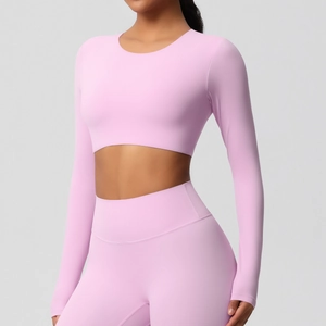 Gros plan du haut de yoga rose à manches longues montrant la texture du tissu élastique