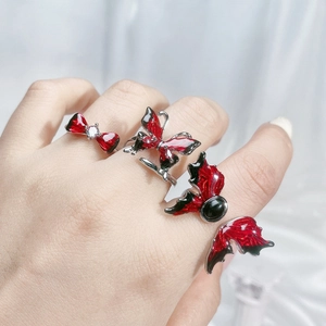Detail of red and black enamel butterfly rings and bow with zircons on model hand