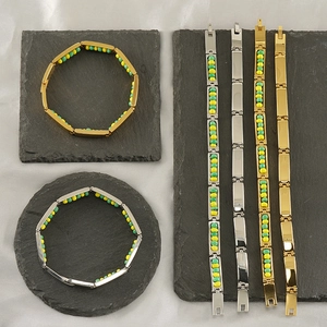 Titanium steel beaded bracelet in gold and silver finish with green and yellow accents