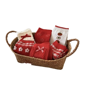 Festive red and white cotton knit socks set with patterns in a brown woven basket