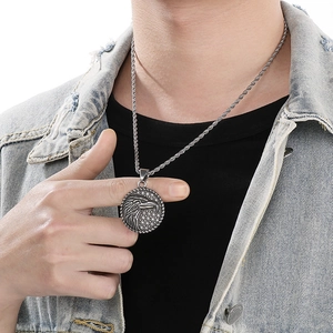 Close-up of a silver eagle pendant with twisted chain on a man in a denim jacket