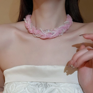 Close-up of multi-layer pink and white beaded choker with woven pearl texture details