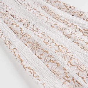 Detailed close-up of intricate white lace floral pattern on the strapless maxi dress