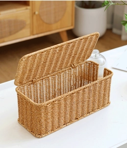 Macro shot of faux rattan woven cable organizer box on a white tabletop home setting
