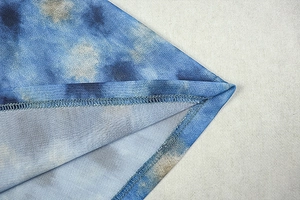 Detail of blue tie-dye knit fabric with fine mesh texture and professional stitching