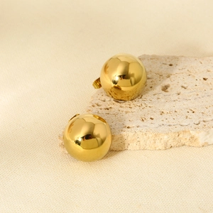Polished 16K gold plated stainless steel ball stud earrings on textured background