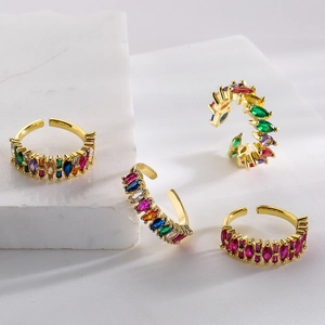 Stack of 18K gold plated rainbow zircon open rings on marble block for women
