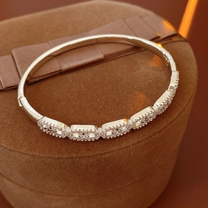 Close-up of a silver bangle with cubic zirconia pavé oval links and cutout details