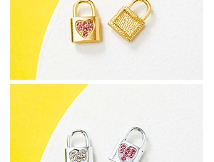 Detailed macro view of heart and square lock charms in gold and silver with pink crystals