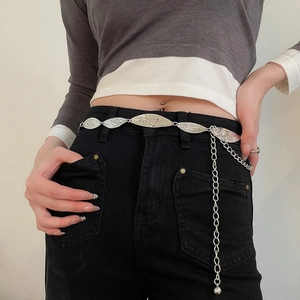 Macro view of silver oval hammer-textured metal chain belt with stylish dangling charms
