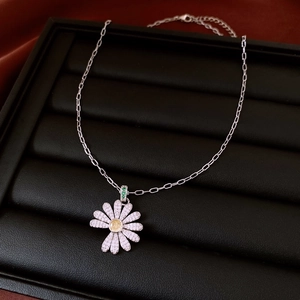 Macro detail of daisy flower pendant with pavé diamonds and yellow gemstone core