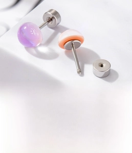 Detailed view of titanium steel stud earrings with purple and pink resin stones