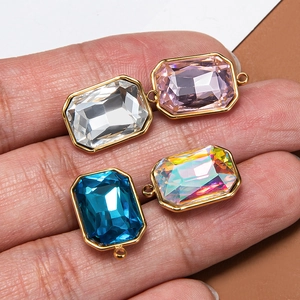 Rectangular crystal charms in gold stainless steel bezels held in hand for size