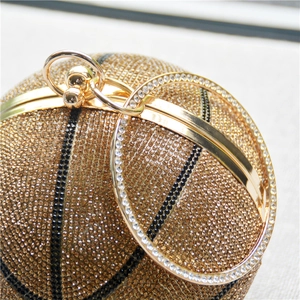 Detailed macro view of sparkling gold and black rhinestones on a spherical basketball clutch