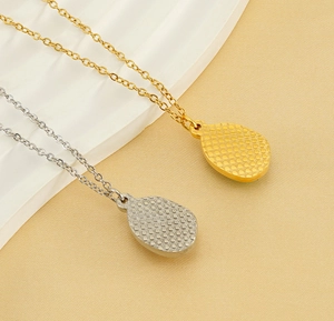 Detailed view of teardrop pendant back featuring honeycomb texture in gold and silver