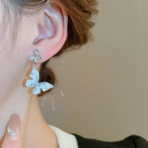 Elegant double butterfly earrings with sparkling crystals and white marble texture wings