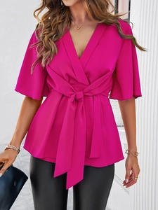 Détail du haut cache-cœur rose fuchsia avec nœud à la taille et manches cloches