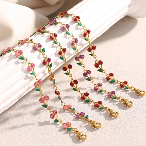 Vue détaillée des breloques cerise sur des bracelets en acier inoxydable plaqué or 18 carats