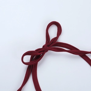 Détail du tissu en maille côtelée bordeaux avec un élégant nœud et texture