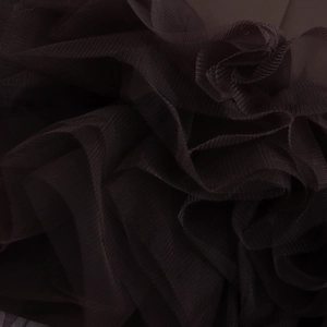Detailed macro shot of layered black mesh fabric showing elegant texture and pleats