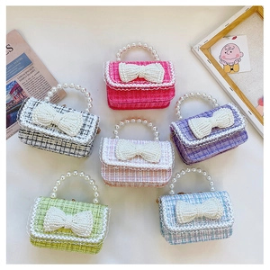 Flat lay of tweed mini bags with pearl handles and large bow details in various colors