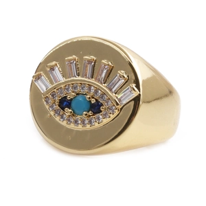 Detailed macro shot of gold evil eye signet ring with turquoise and baguette zircons