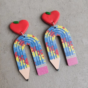 Detail of pencil earrings with red apple top and colorful mosaic pattern on arch shape