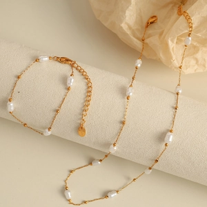 Elegant irregular pearl necklace and bracelet set with 18k gold plating on beige stand