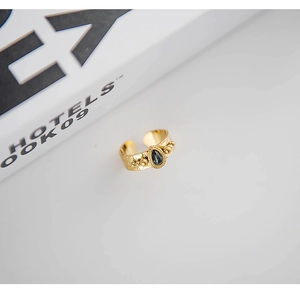 Close-up of 18K gold plated hammered ring with oval black gemstone and bead detail