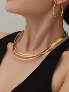 Détail d'un collier chaîne serpent multicouche plaqué or 18 carats avec boucles d'oreilles