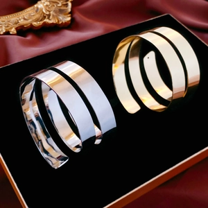 Close-up of polished gold and silver spiral cuff bracelets on black velvet display