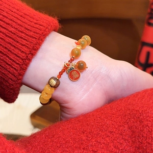 Detailansicht eines roten Achat-Perlenarmbands im neuen chinesischen Stil mit Goldanhänger