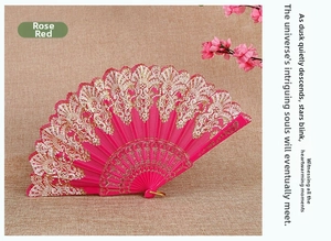 Detail of rose red folding fan with ornate gold lace patterns and plastic frame