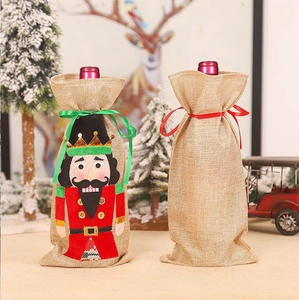 Detail of Christmas nutcracker wine bottle bags made of natural linen with festive ribbons