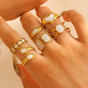 Stackable set of gold plated titanium steel rings with white enamel heart and geometric designs