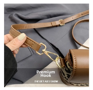 Close-up of golden metal hook on brown leather and leopard print shoulder bag