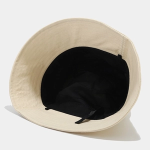 Detail view of the beige canvas bucket hat with black lining and internal sweatband