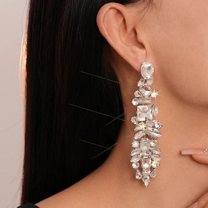 Detailed view of silver luxury geometric crystal fringe earrings on a female model