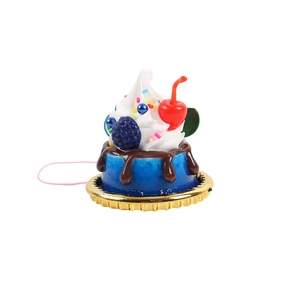 Miniature blue faux cake with cherry, chocolate glaze and cream on a golden base