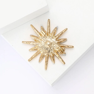 Detailed back view of gold starburst brooch showing secure pin fastener mechanism