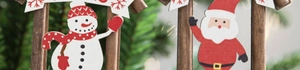 Detailed view of wooden cabin Christmas ornaments with Santa and Snowman on a tree