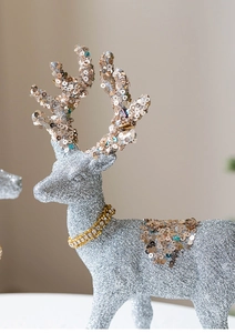 Close-up of a silver glitter reindeer figurine with gold sequins and a rhinestone collar