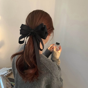 French style large black satin bow hair clip with long ribbons on a ponytail